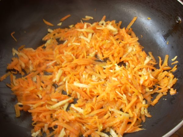 На разогретой глубокой сковороде обжарьте сначала нашинкованный лук, затем - натертую морковь.