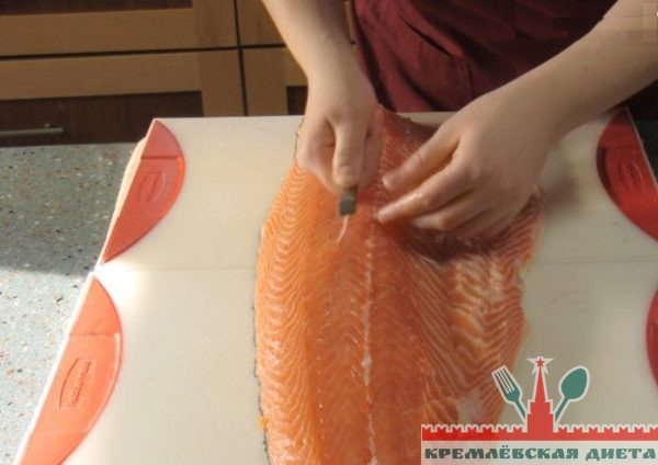 Используя щипцы или пинцет, удалите кости и ребра лосося вдоль толстого заднего хребта.

