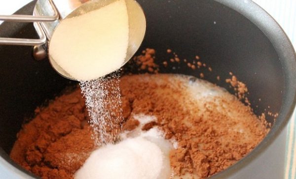 Затем добавьте в молоко одну столовую ложку кокосового масла, ореховое масло, какао-порошок, ваниль, сахарозаменитель (или сахар). Тщательно размешайте. Когда всё растворится, слегка взбейте миксером, не снимая с огня, чтобы смесь стала однородной.