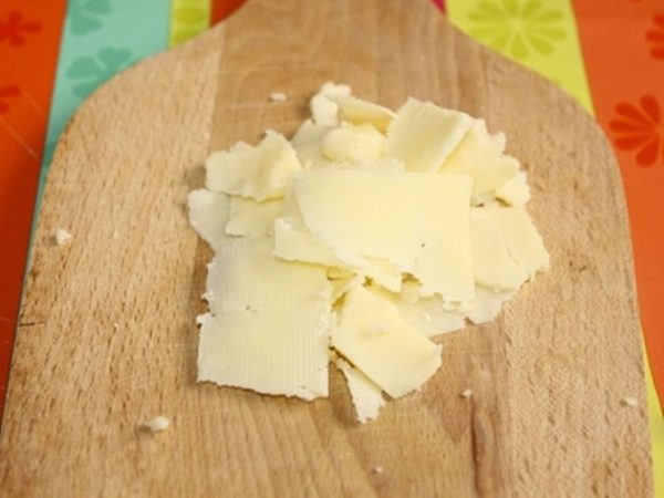 Сыр нарезать тонкими пластинками или натереть на крупной терке.