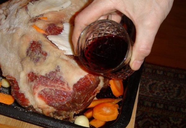 Обкладываем мясо со всех сторон оставшимися овощами, вливаем вино, поливаем оливковым маслом и закрываем фольгой.