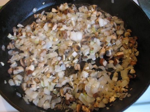 Тем временем, лук, шампиньоны и чеснок шинкуем. Обжариваем их на сковороде в сливочном масле до золотистого цвета лука.