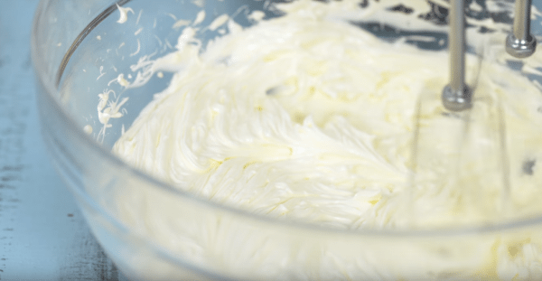 Поместите масло в миску и взбивайте примерно в течение 10 минут, пока масло не станет бледно-жёлтым.