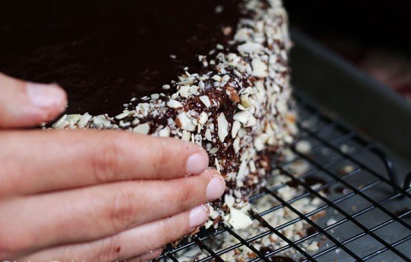 Обсыпьте, прижимая, измельченный миндаль по бокам и наружному краю торта. Охладите часик, чтобы "установилась" глазурь.