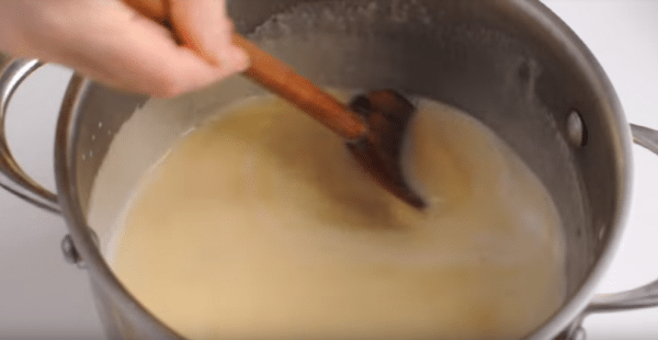 Затем в яичную смесь начинайте вливать тонкой струйкой горячее молоко, все время перемешивая лопаточкой.
