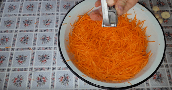 Натираем морковь соломкой и выдавливаем чеснок. Добавляем все специи и перемешиваем.